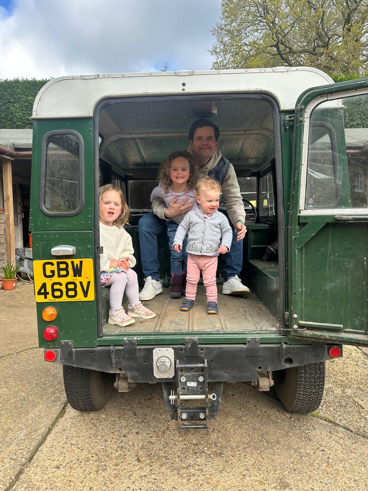 Alex Davey with daughters Arabella, Araminta and Beatrice beside a Land Rover — Davey and Daughters car sourcing