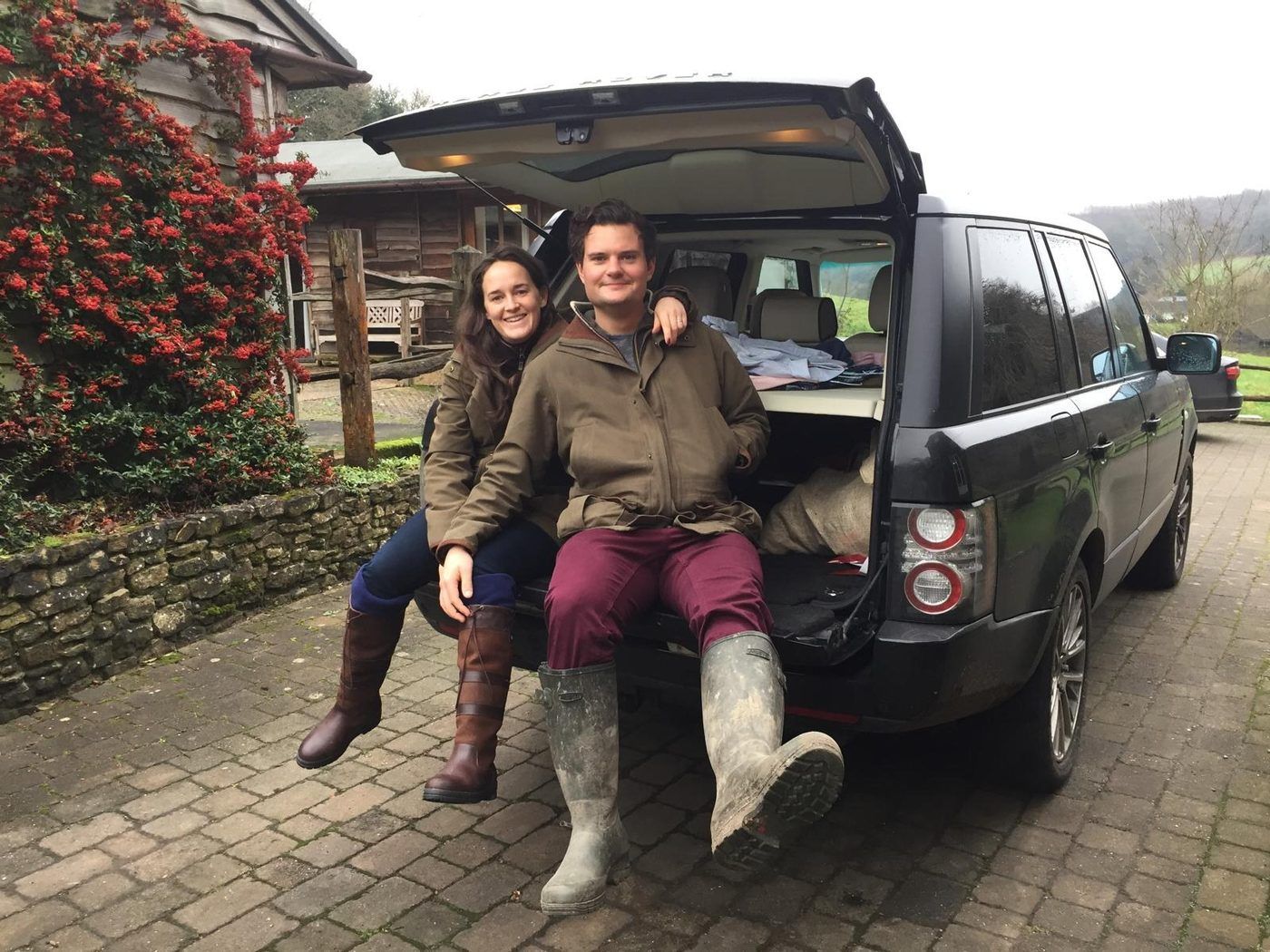 Alex Davey with a client at handover, on the tailgate of a Range Rover